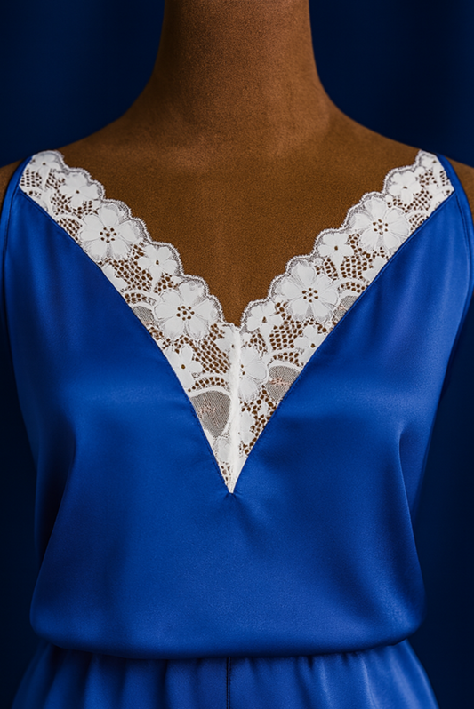 Blue satin romper with lace detailing on a mannequin against a dark background