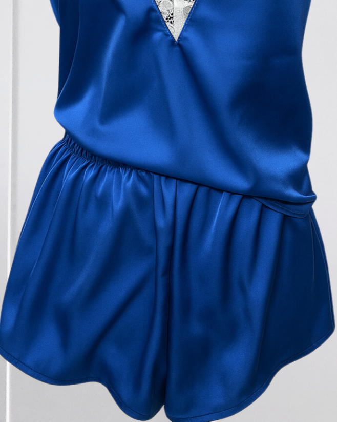 Blue satin romper with lace detailing on a mannequin against a white background