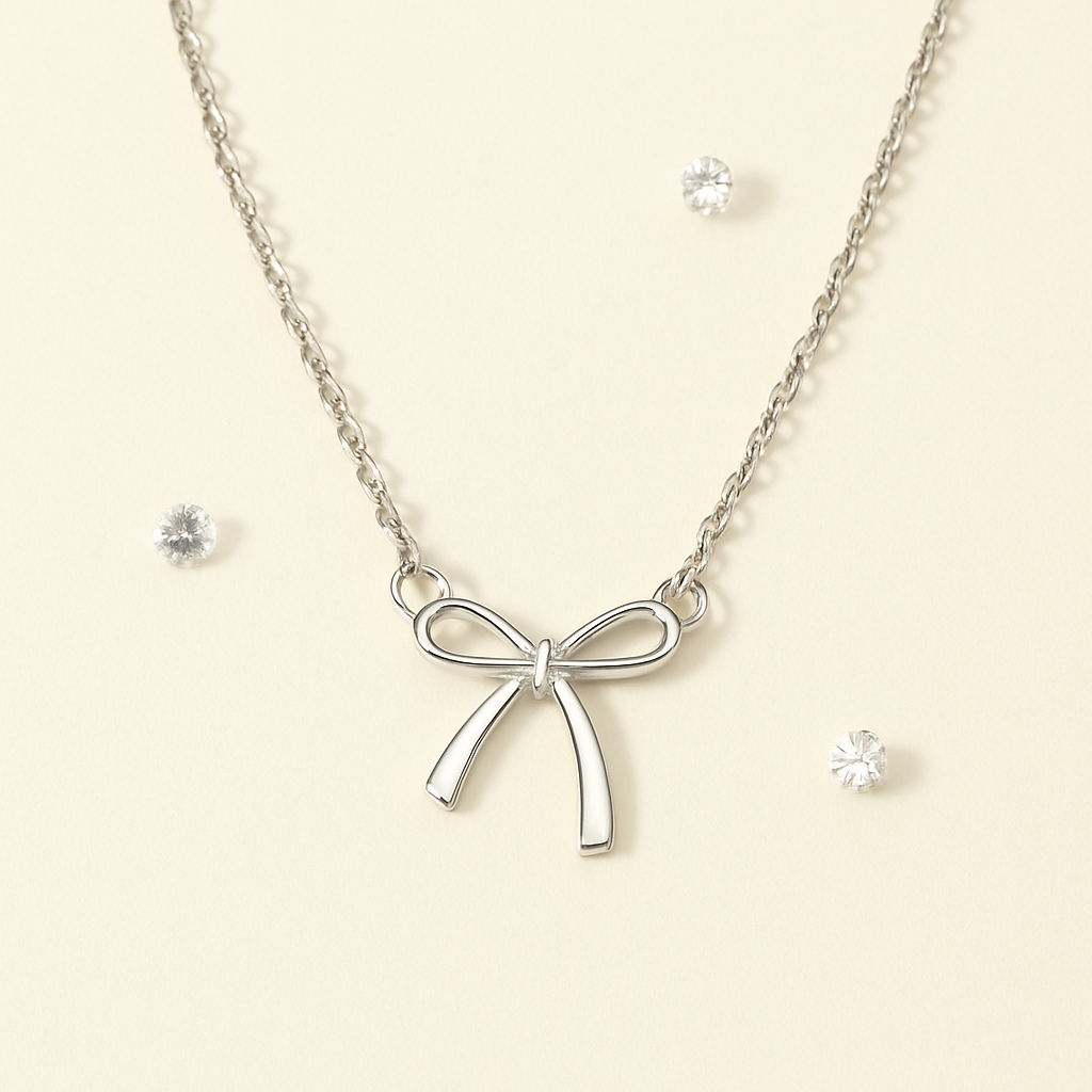 Silver bow necklace on a beige background