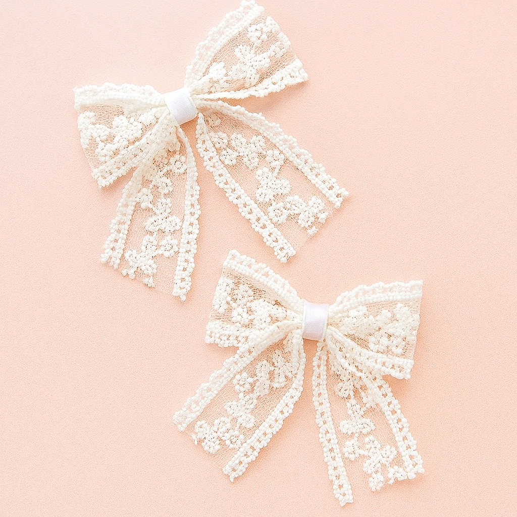 Two white lace bows on a pink background